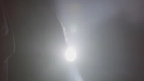 Silhouette of a Hand Wielding a Knife in Front of a Shining Light Stock Footage 208758445