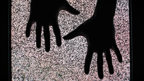 Silhouette Hands Appearing and Touching on TV Static Stock Footage 307441896