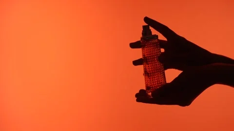 Silhouette of Hands Holding a Perfume Bottle Stock-Footage 313525653