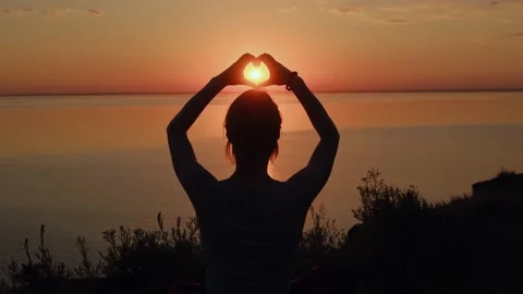 Silhouette of hands making heart shape at sunset. Stock Footage 201413784