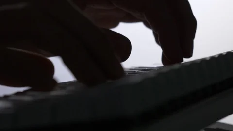 Silhouette of Hands Typing On a Computer Keyboard Stock Footage 86454428