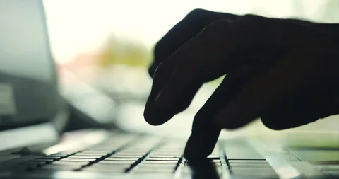 Silhouette of hands typing on computer keyboard Stock Footage 113897875