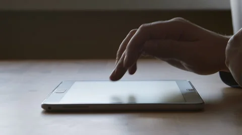 A silhouette of A hands of young man touching on a tablet PC at the table Stock Footage 66466536