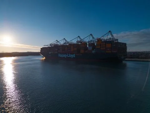Silhouette of Hapag-Lloyd container ship at sunset with sun reflection Stock Photos