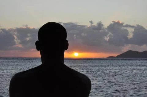 Silhouette of a head man from the back at sunset with the sea Stock Photos