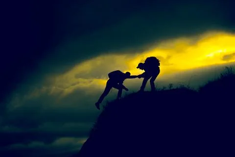 Silhouette of helping hand between two climber Stock Photos