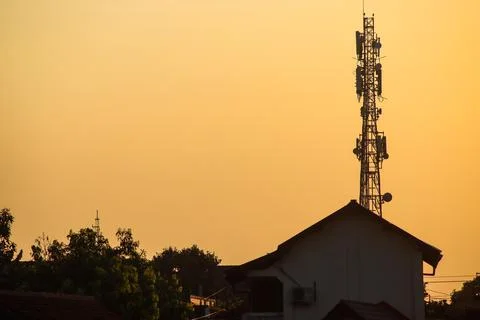 Silhouette of High Telecommunication Tower with Cellular Antennas Above Res.. 写真素材