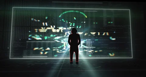 Silhouette of hooded hacker standing in front of a digital screen wall Stock Footage 129502226