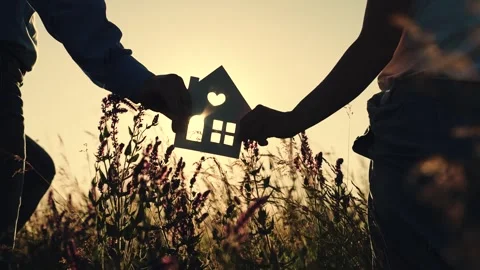 Silhouette of the house in the hands on the background of the sunset close-up Stock Footage 250070179