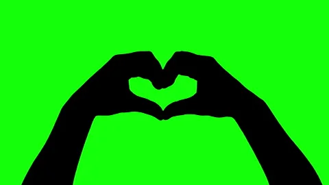 Silhouette of human hands making heart gesture with fingers on green background. Stock Footage 335693789