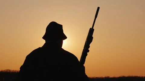 Silhouette of hunter with rifle at sunset during winter hunting season in s.. Stock Footage 334985405