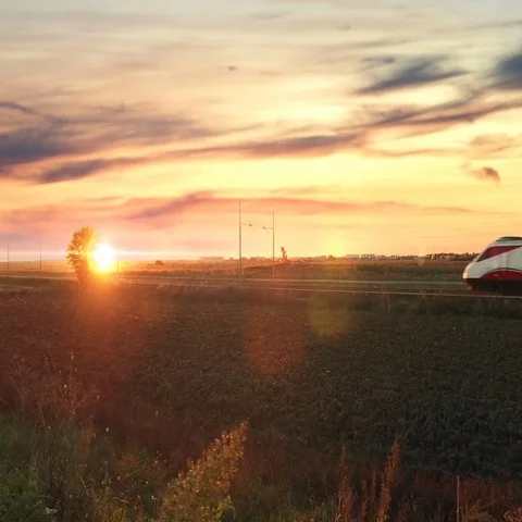 Silhouette of an Italian passenger train at sunset Stock Footage