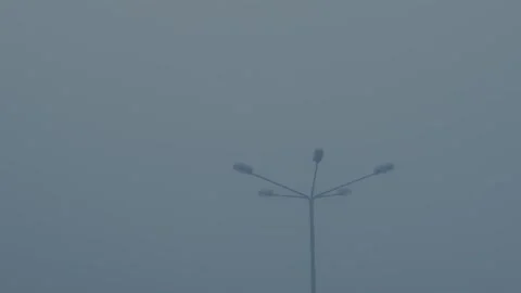 Silhouette of lamppost in the thick gray haze of dramatic overcast sky Stock Footage 253022973