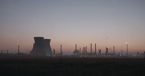 Silhouette of a large oil refinery during sunrise Stock Footage