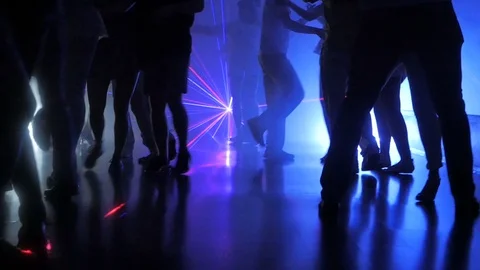 Silhouette of legs of dancing people on latino salsa party with multi-colored Stock Footage