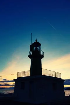 Silhouette of a lighthouse at sunset Stock Photos