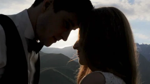 Silhouette of a loving couple on the background of the setting sun, mountains. Stock Footage 93565513