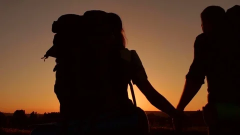 Silhouette of loving couple of tourists at sunset. Stock Footage