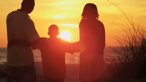 Silhouette of loving ethnic family enjoying sunrise and togetherness on the Stock Footage