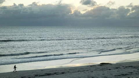 Silhouette man alone walking on isolated beach 6K Stock Footage 313796871