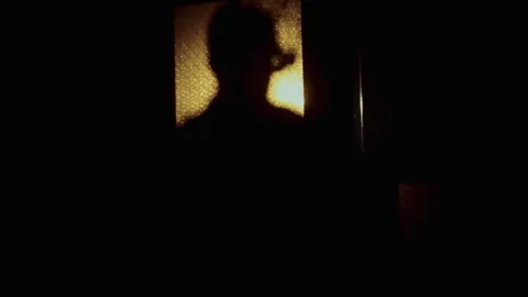 Silhouette of a man and scissors on the Window Vídeo Stock 259858458
