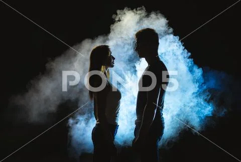 The silhouette of man and woman in the smoke Stock Photos