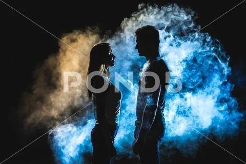 The silhouette of man and woman in the smoke Stock Photos