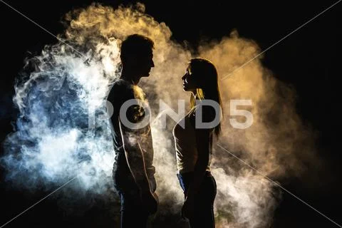 The silhouette of man and woman in the smoke Stock Photos