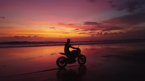 Silhouette of man biker driving his bike motorbike beside the natural lake ocean Stock Footage 230273645