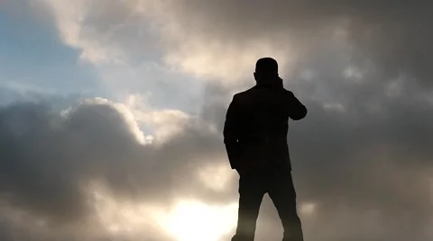 Silhouette of man with binoculars clouds background slow motion Stock Footage 58575626