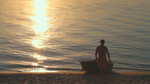 Silhouette of a man with a boat at sunset 库存影片 68922883