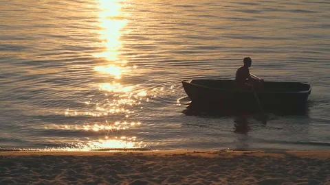 Silhouette of a man with a boat at sunset 库存影片 70924429