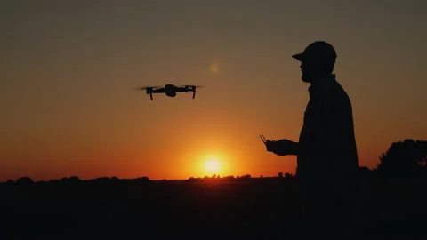 Silhouette of a man controlling a drone at sunset Stock Footage 139743927