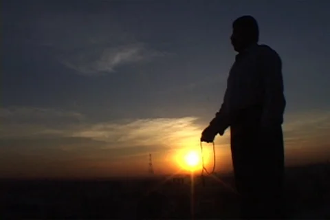 Silhouette of man counts Prayer beads in Iraq Stock Footage 86753211
