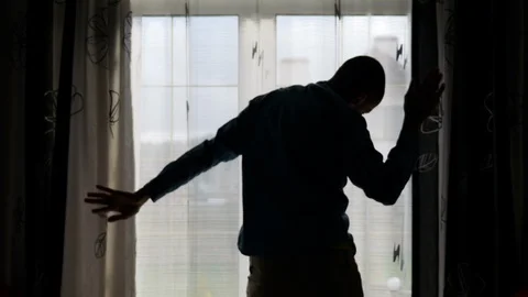 Silhouette of a man dancing against the window. Stock Footage 97315699