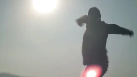 Silhouette of man dancing funny dance on sun background. Stock Footage 87914920