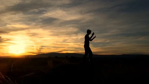 Silhouette of a man doing Tai Chi on a hilltop in Portugal. Stock Footage 115844865