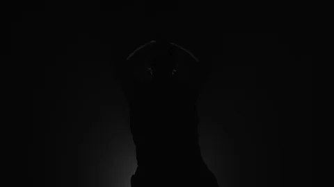 Silhouette of man doing warmup stretching before workout Stock Footage 104065524