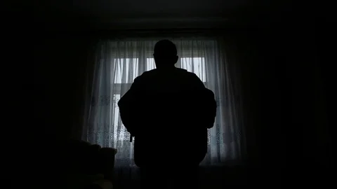 Silhouette of a man dressed in the room Stock Footage 77076675