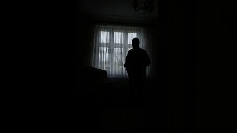 Silhouette of a man dressed in the room Stock Footage 77076905