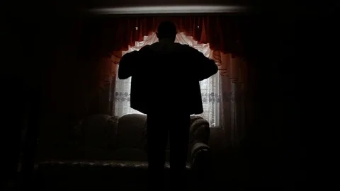 Silhouette of a man dressed in the room Stock Footage 80674674