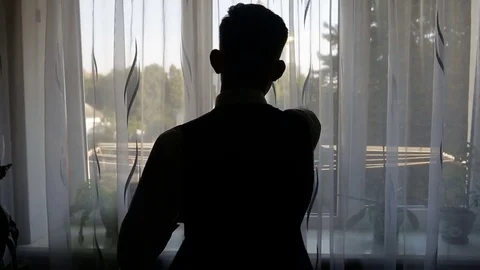 Silhouette of a man dressed in the room Stock Footage 84069522