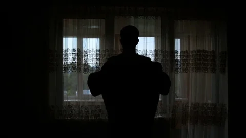 Silhouette of a man dressed in the room Stock Footage 85192216
