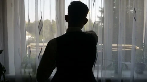 Silhouette of a man dressed in the room Stock Footage 87649024