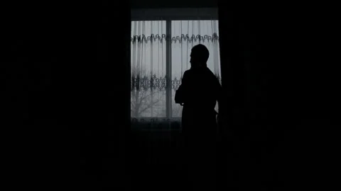 Silhouette of a man dressed in the room Stock Footage 88489458