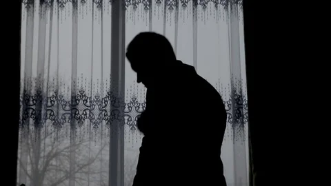 Silhouette of a man dressed in the room Stock Footage 89976133