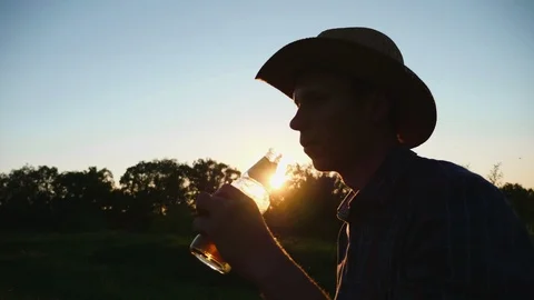 Silhouette of man drinking beer during sunset Stock Footage 107374901