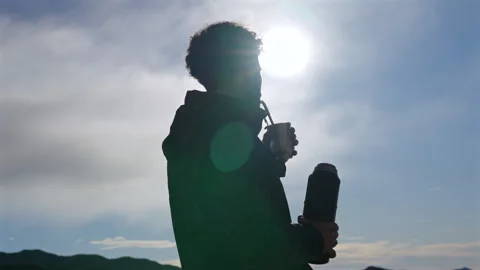 Silhouette of man drinking yerba mate outdoors against bright sun and open sky Stock Footage 328295666