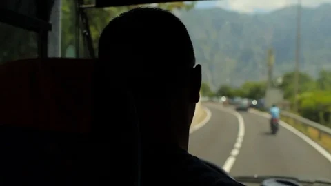 The silhouette man driver of a bus driving along a mountain road Stock-Footage 92127642