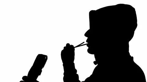 Silhouette of a man eating a bread straw on a white background Vídeo Stock 247529289